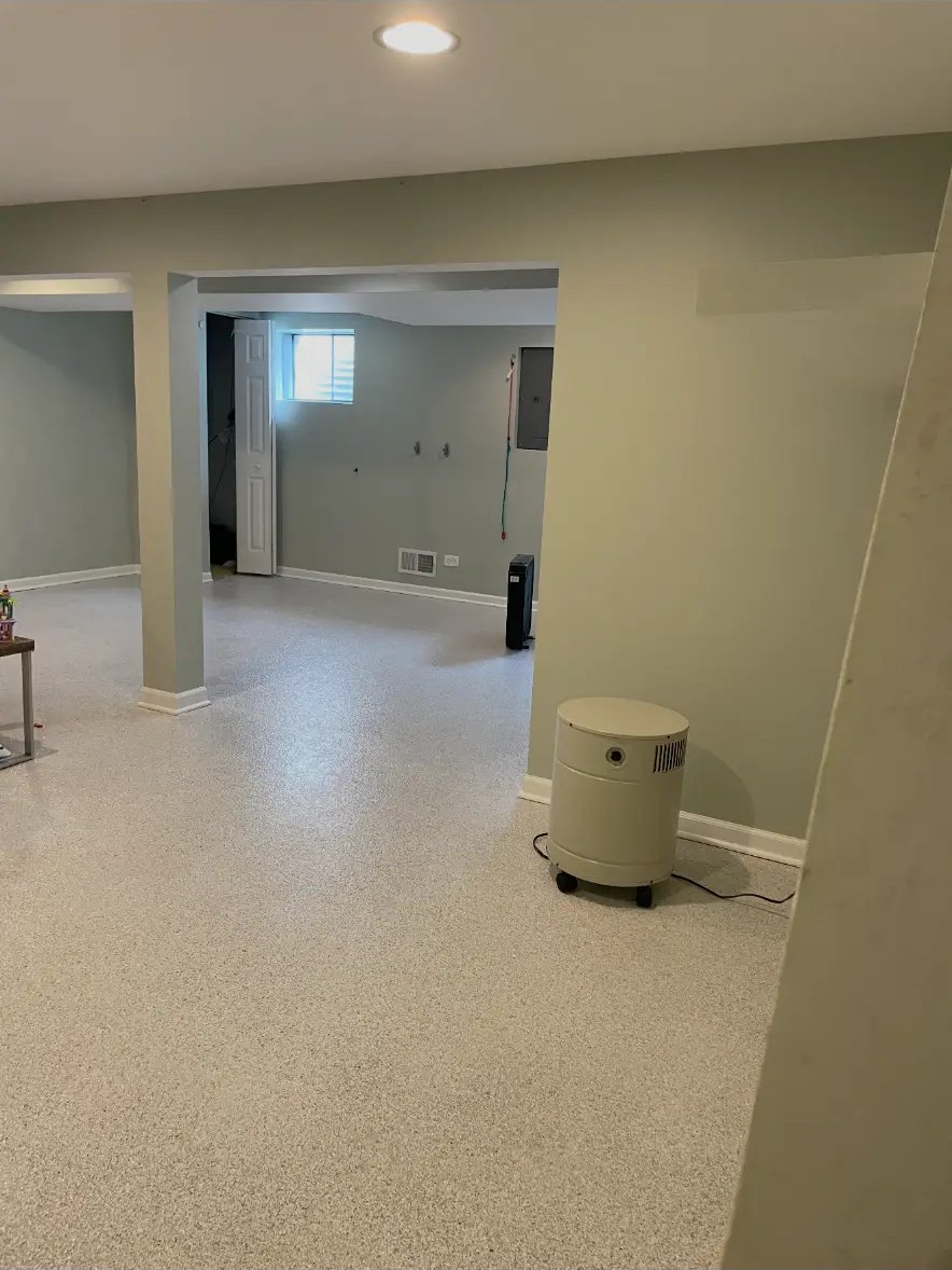 Basement after restoration with smooth gray walls and new speckled flooring