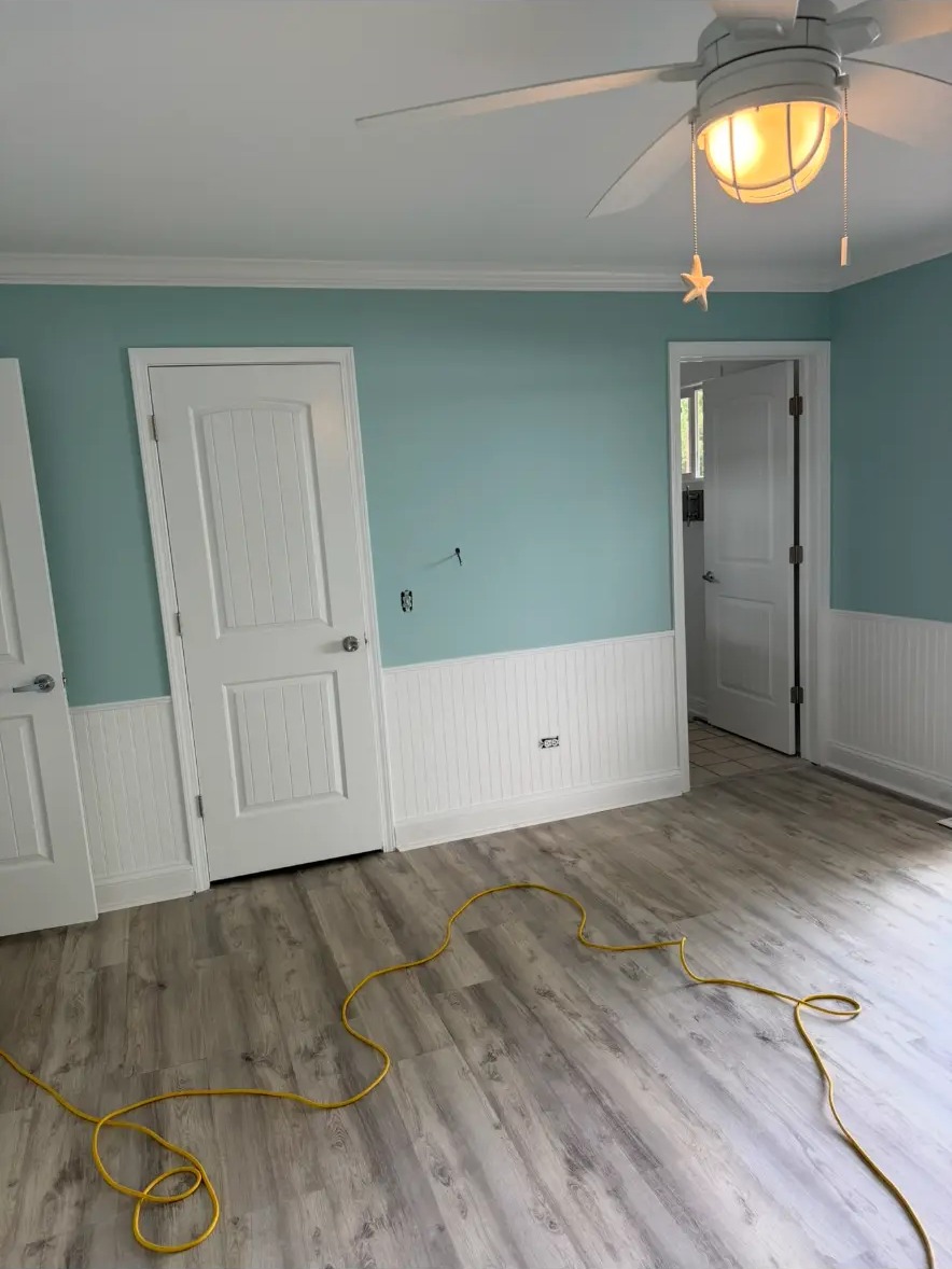 Same bedroom wall after TV mount removal, patching, and paint touch-up
